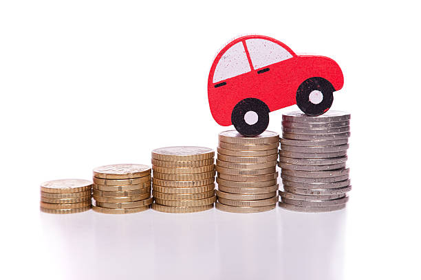 Red car cutout climbing stacks of coins stock photo