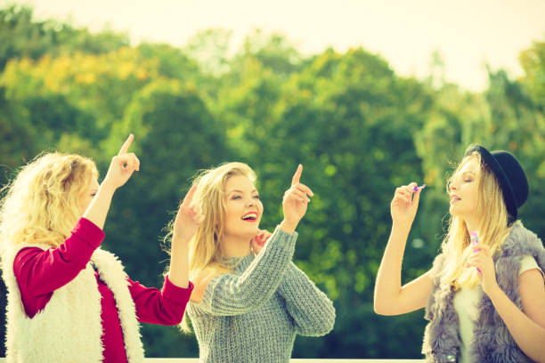 istock Women friends blowing soap bubbles. 979463074