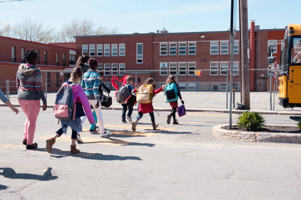 Multi-Ethnic Group of elementary school kids getting in a school bus at school's out.