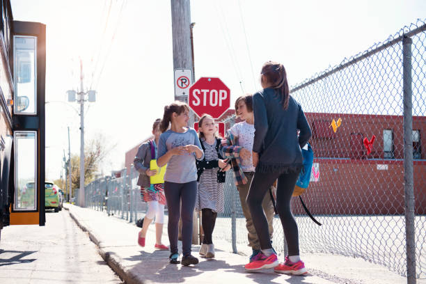 istock Group of elementary school kids getting out a school bus at school's out. 979465774