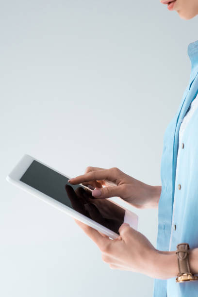 istock cropped shot of young woman using tablet isolated on grey 979482730