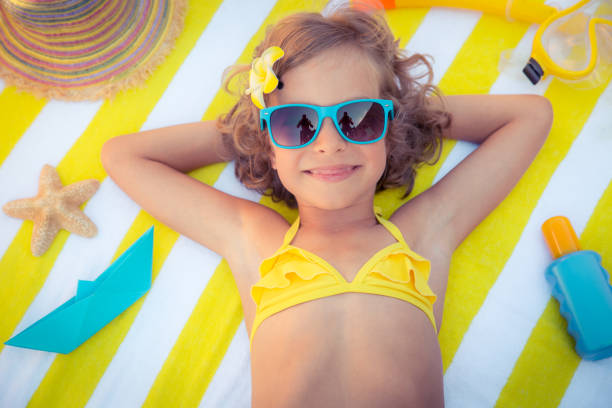 Happy child on the beach. Kid having fun outdoors. Summer vacation concept. Top view portrait