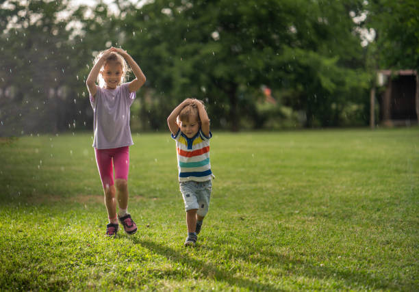 istock Brother and sister running from the rain 979486830