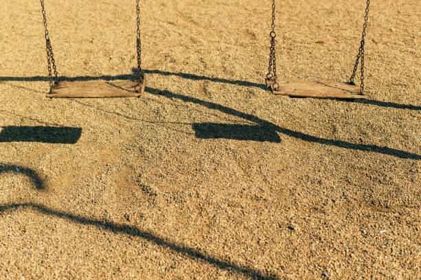 istock Pair of empty wooden swings 979493096