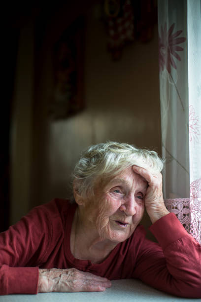 istock An emotional old lady is sitting at the kitchen table. 979497456