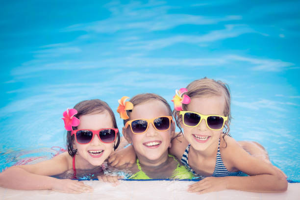istock Happy children in the swimming pool 979499008