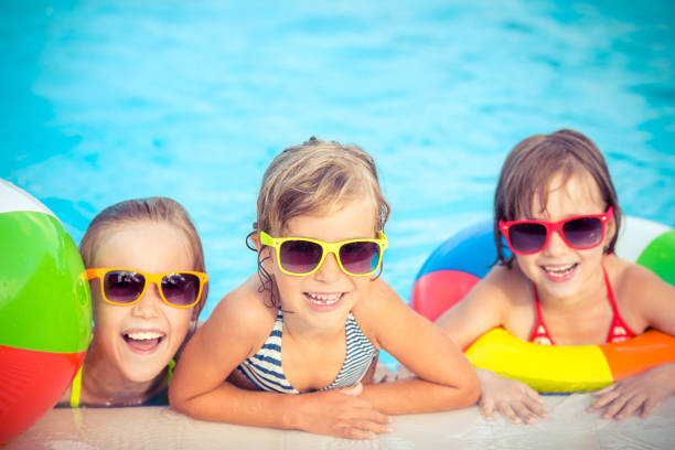 istock Happy children in the swimming pool 979499232
