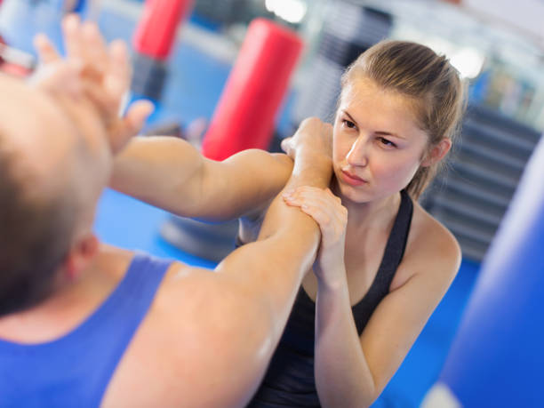 istock Young female and trainer are training kick  in gym 979501788