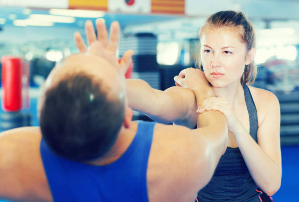 istock Woman and trainer practicing punches in gym 979501824