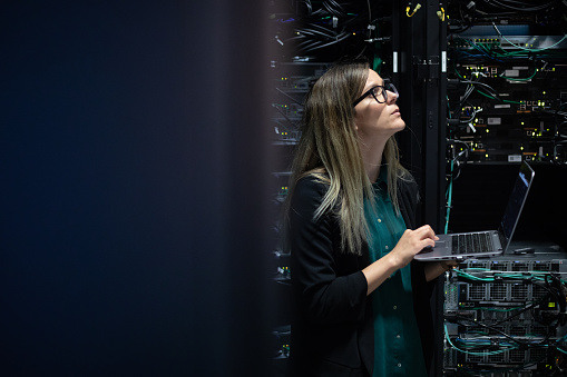 Female IT Engineer Checking Supercomputer Network Efficiency.