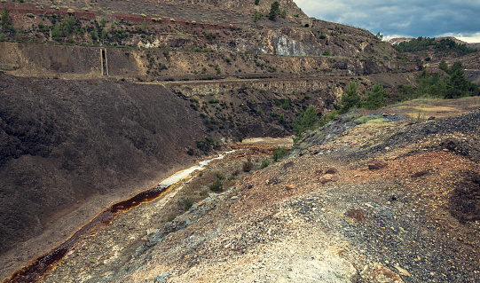 Red river by minerals between cliffs in Zaranda, Spain