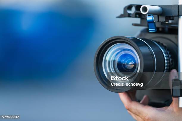 Camera Lens Attached To A Camera And Hand Focusing Close Up Detailed With Smooth Blue Background And Sunset Reflections Concept For Videography Cinematography Vlogging Video Television Movies Making Stock Photo - Download Image Now