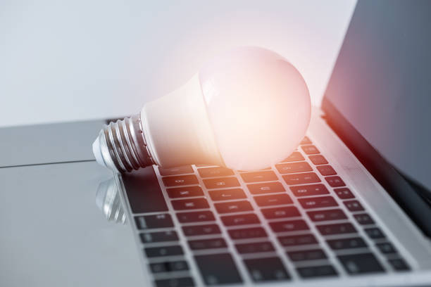 istock Close-Up Of Light Bulb On Laptop At Table 979546220