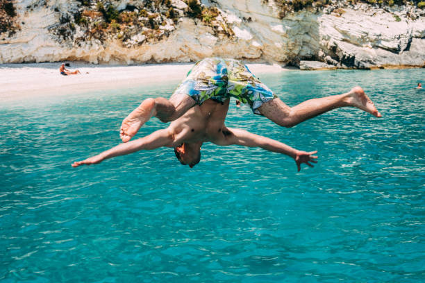 istock Young Man Jumping in the Sea 979547332