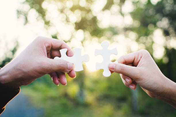istock Cropped Hands Holding Jigsaw Pieces At Park 979556054