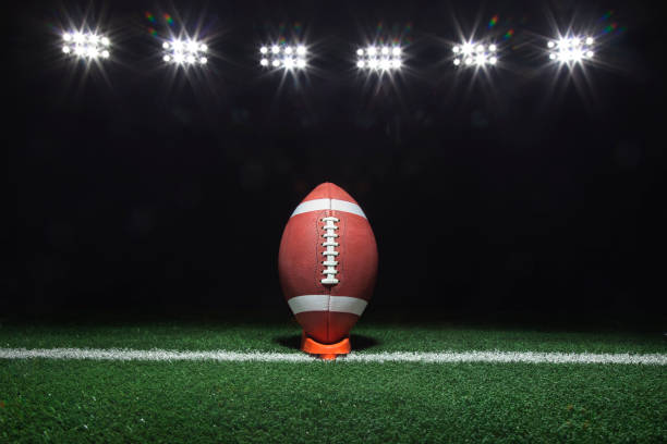 istock Football on a tee under lights at night 979556172