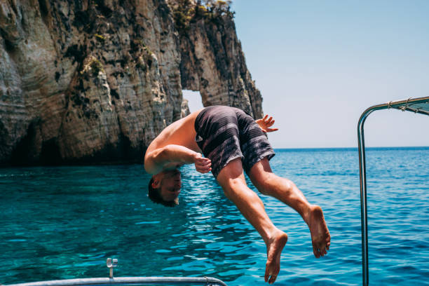 istock Young Man Jumping from a Boat on a Zakynthos Boat Cruise 979559410