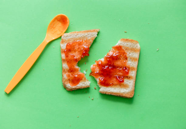 сломанный ломтик тоста хлеб и чайная ложка с вареньем - freedom sandwich bread food стоковые фото и изображения