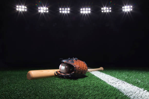 istock Baseball, mitt and bat on field under lights at night 979576126