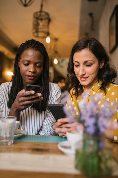 istock Two young women having fun with their smart phones 979576394