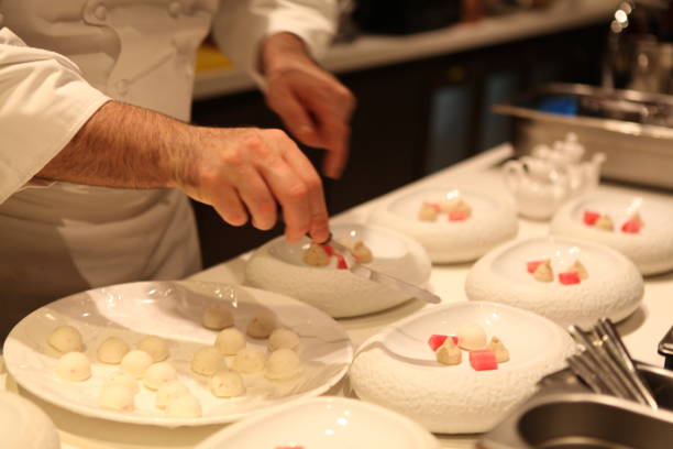 Michelin Starred Chef is plating a  dessert in a white stylish bowl.