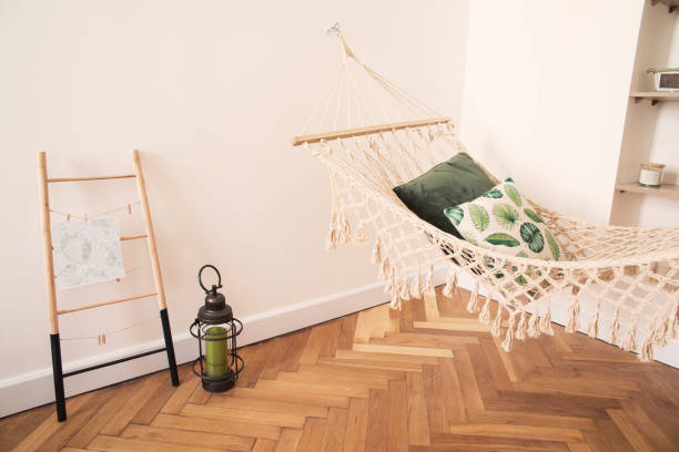 istock Modern and stylish bedroom with natural string hammock. Bright and sunny bedroom with brown wooden parquet. 979585618