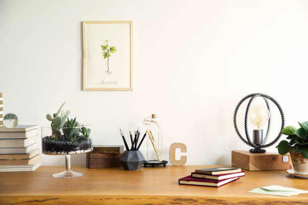 istock Vintage, creative home office interior with wooden desk, books, notebooks, romantic illustrations of plants, table lamp and office accessories. Stylish space for freelancer. 979588426