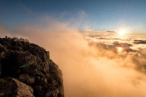 Beautiful dramatic sunset at Table Mountain National Park in South Africa, previously known as the Cape Peninsula National Park. Landscape with sunlight shining through golden clouds.