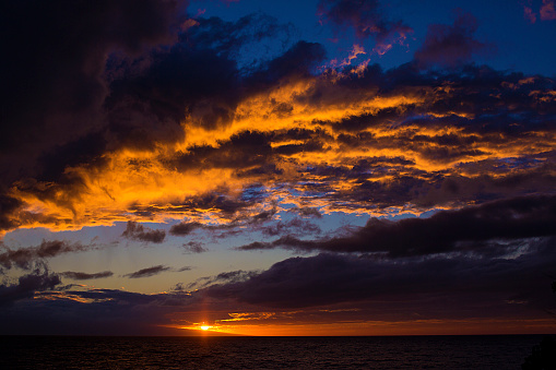 Beautiful blue, purple, orange and gold sunset just off the coast of Kauai, Hawaii.