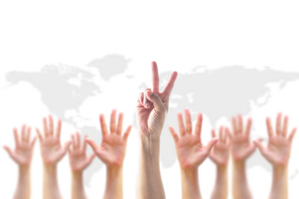 istock Leader's two fingers V victory sign among blur hands crowd group for World participation, leadership, volunteer concept 979620186