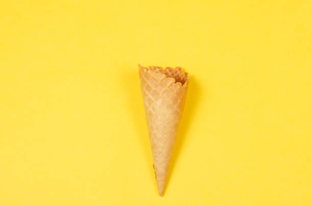 istock Ice cream waffle cone over yellow background with copy space for text, logo or wordings insertion or decoration, summer cold sweet snack 979623336
