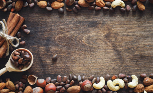 istock Different nuts on a wooden table. Cedar, cashew, hazelnut, walnu 979626248
