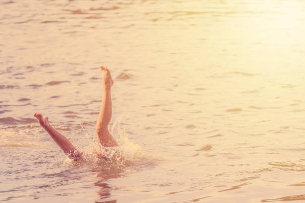 istock Girl falling jumping into the water with splash. Recreation concept. Toned image. 979626576