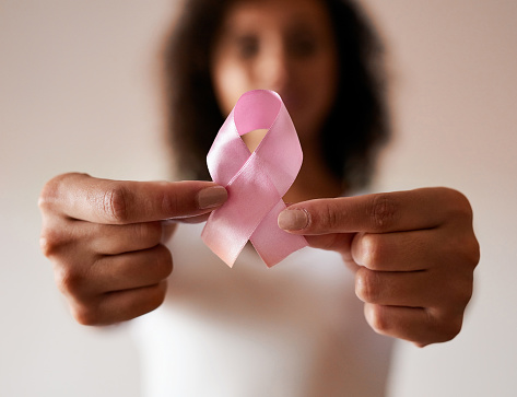 Cropped shot of a woman holding a pink breast cancer awareness ribbon