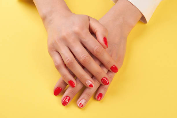 istock Manicured hands isolated on yellow background. 979631196