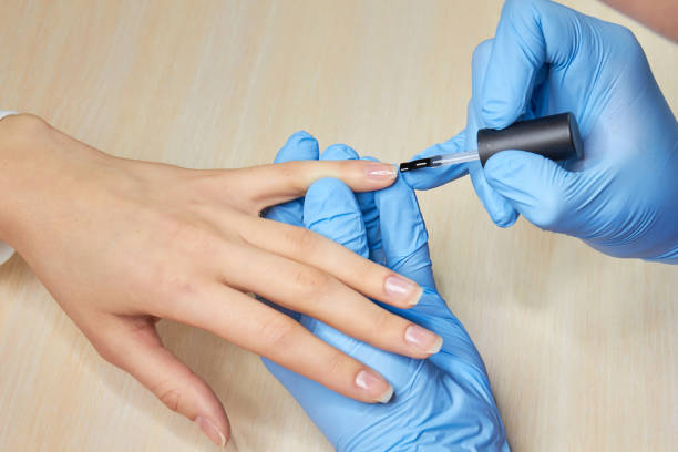 istock Manicurist applying colorless varnish. 979634728