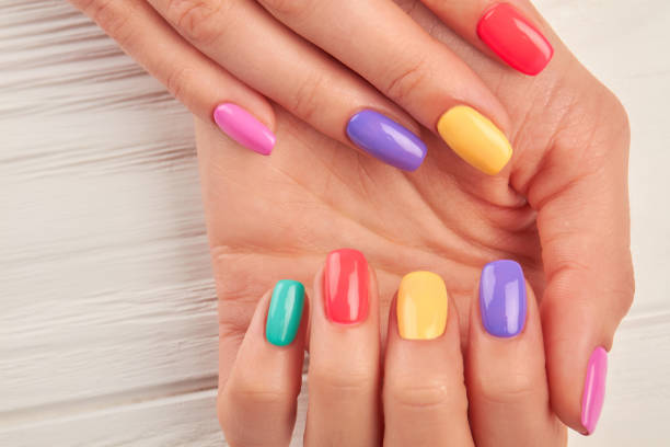 istock Woman hands with multicolored nail polish. 979644594