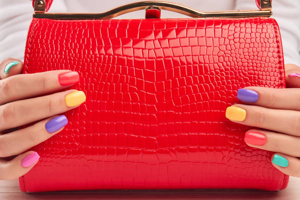istock Red lacquered handbag in female hands. 979644930