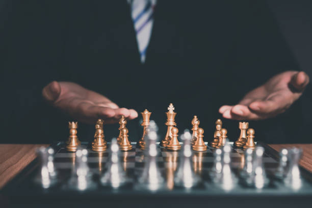 istock Businessman inviting to play chess board game for ideas and competition and strategy. 979648068