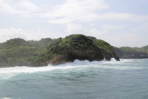 istock Natural cliff formation with the wave at Timang Beach 979670800