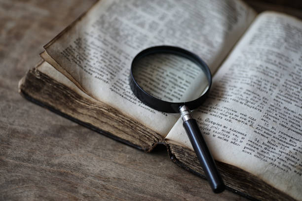 istock Old books on a wooden table and magnifier 979671984