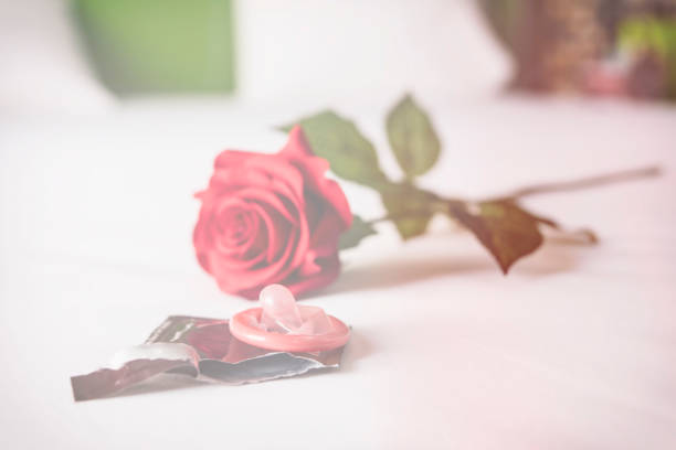 istock Condom and red rose on bed, Valentine concept 979705214