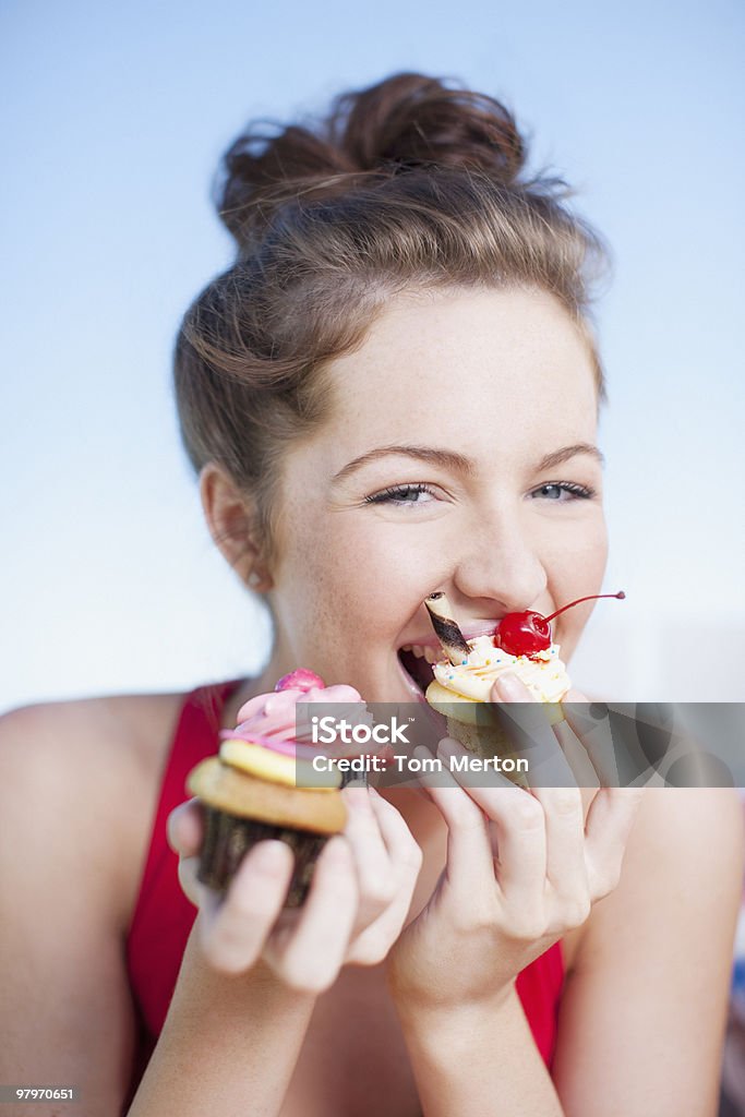 Donna mangiare Cupcake - Foto stock royalty-free di Donne