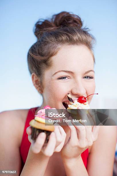 Donna Mangiare Cupcake - Fotografie stock e altre immagini di Donne - Donne, Felicità, Mangiare