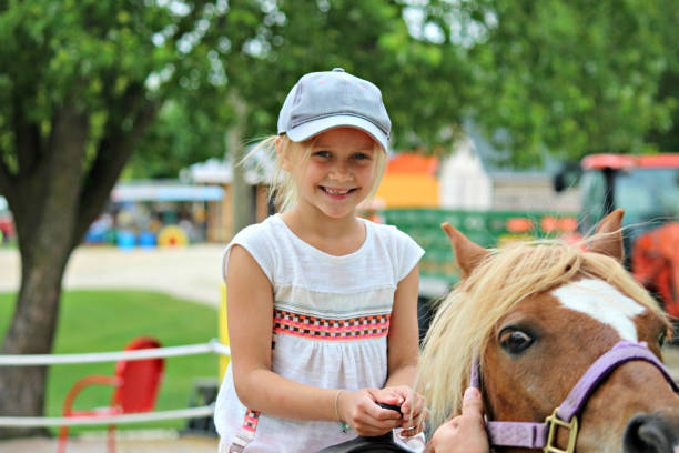 jeune fille chevauchant un cheval dans une ferme du wisconsin, amérique - pony photos et images de collection