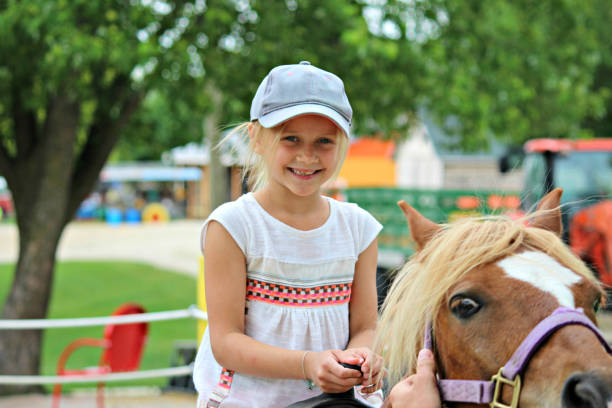 молодая девушка верхом на лошади на ферме в висконсине, америка - pony стоковые фото и изображения
