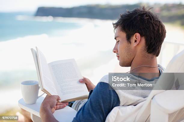 Homem Com Copo De Café Ler Um Livro Na Cadeira De Recosto Esquecendo - Fotografias de stock e mais imagens de Praia