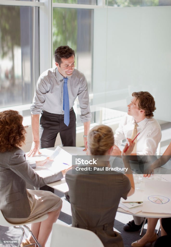 Empresários em reunião em uma mesa de conferência - Foto de stock de Reunião royalty-free