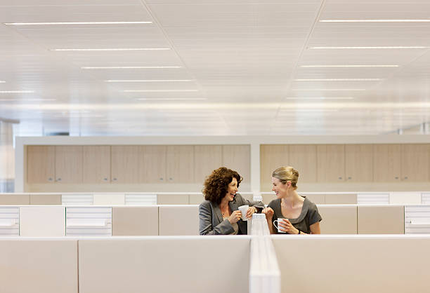 Businesswomen with coffee gossiping in office cubicles  gossip stock pictures, royalty-free photos & images