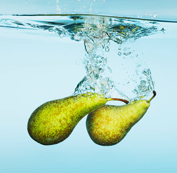 pere spruzzi in acqua - two pears foto e immagini stock